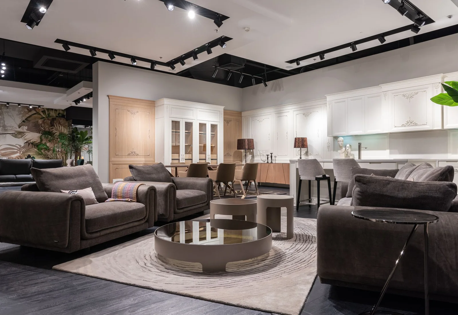 Upholstered sofas and occasional tables arranged in a daylit furniture showroom